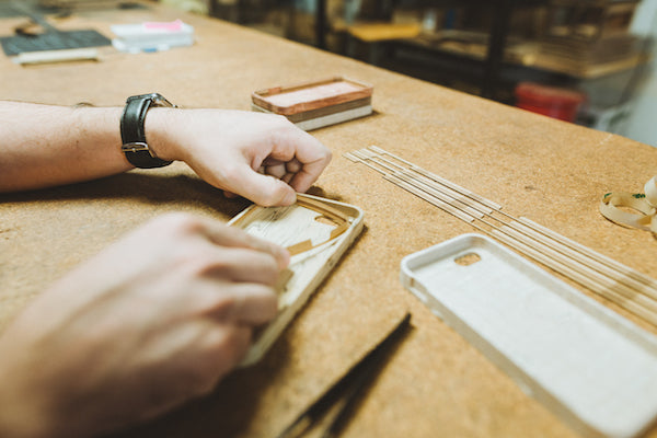 hand assembling a wooden iphone case with veneer strips