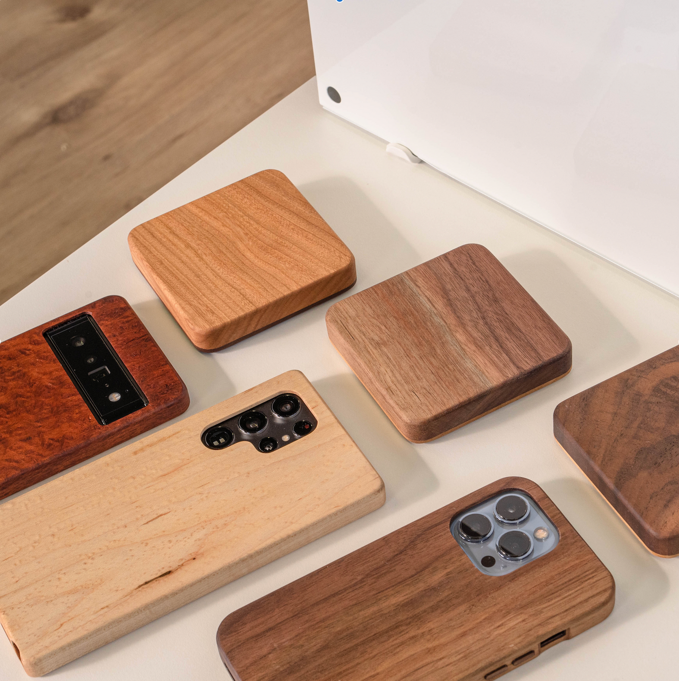 three wooden phone cases and three wooden wireless chargers