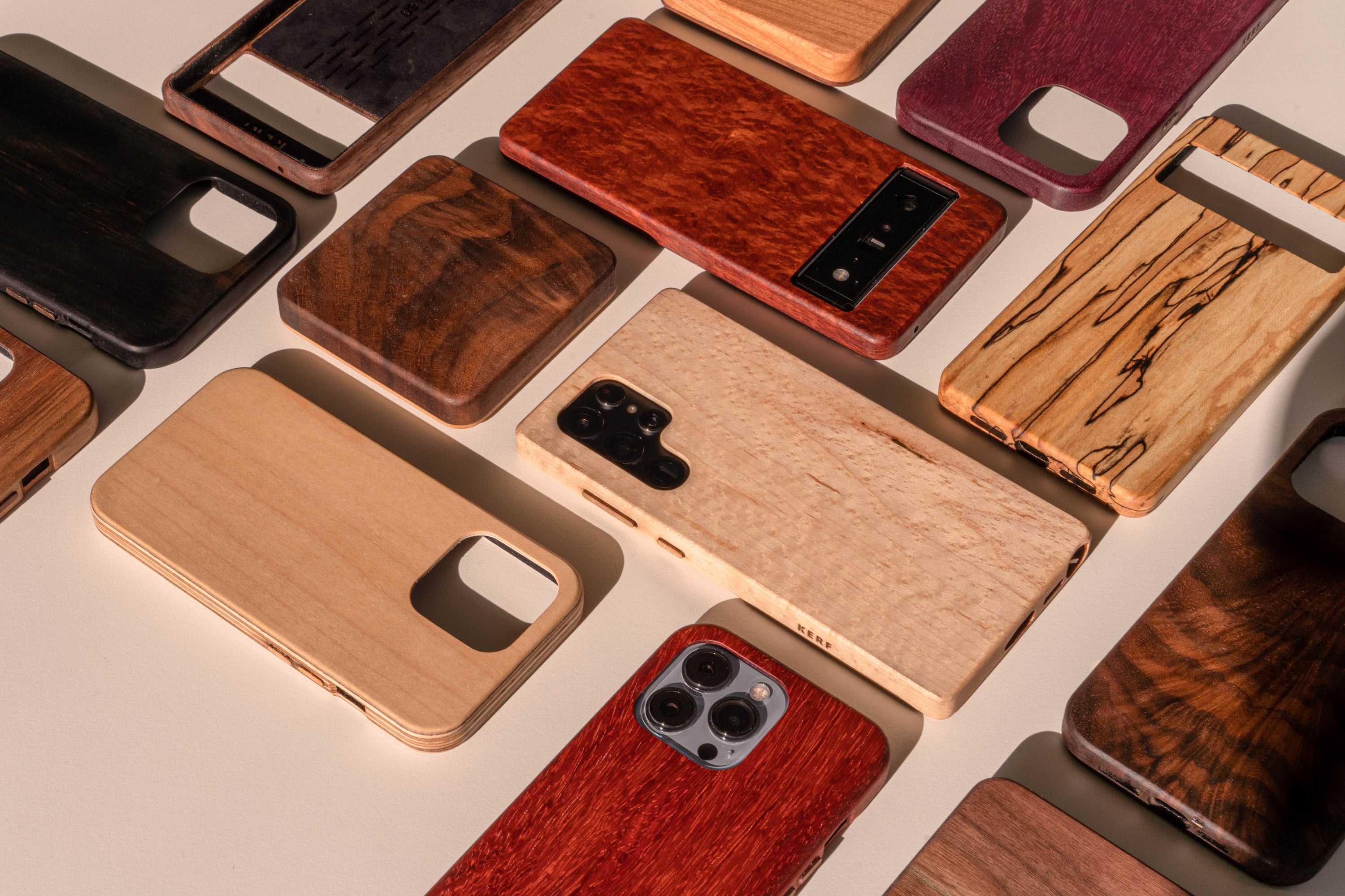 an array of various wooden phone cases for pixel, iPhone, galaxy phones with colorful wood species