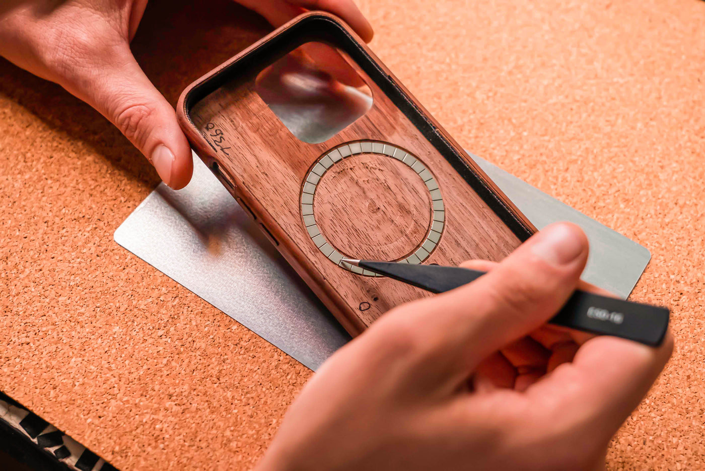detail photo of adding magsafe magnets to a wooden iphone case by hand